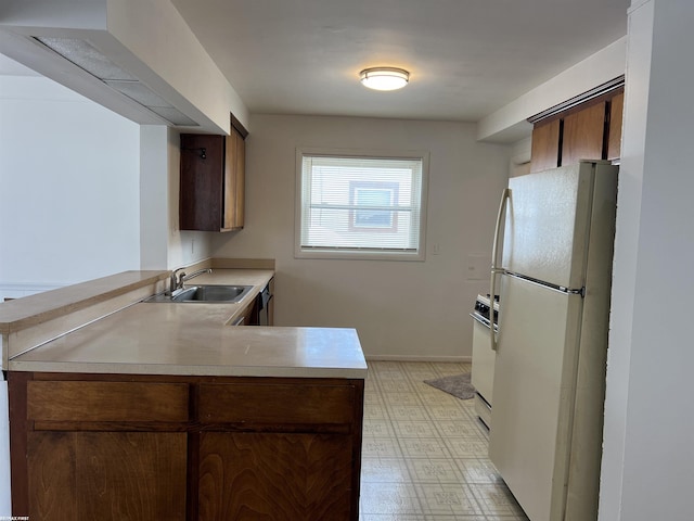 kitchen featuring sink, white appliances, and kitchen peninsula