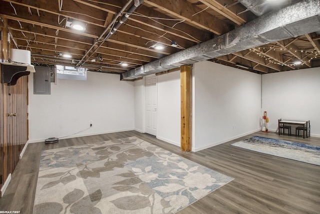 basement featuring hardwood / wood-style flooring and electric panel