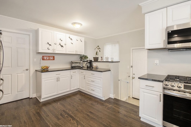 kitchen with white cabinetry, appliances with stainless steel finishes, crown molding, and dark hardwood / wood-style flooring