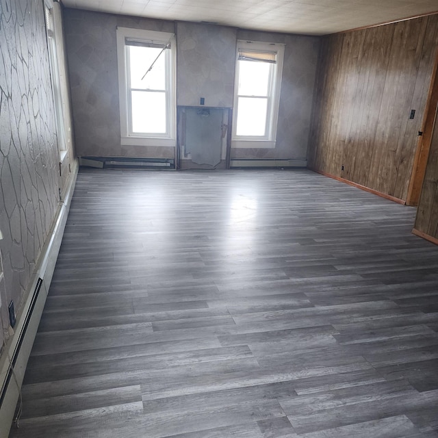 unfurnished room with dark hardwood / wood-style flooring and a baseboard heating unit