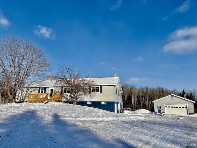 view of front of home with a garage, an outbuilding, and a deck