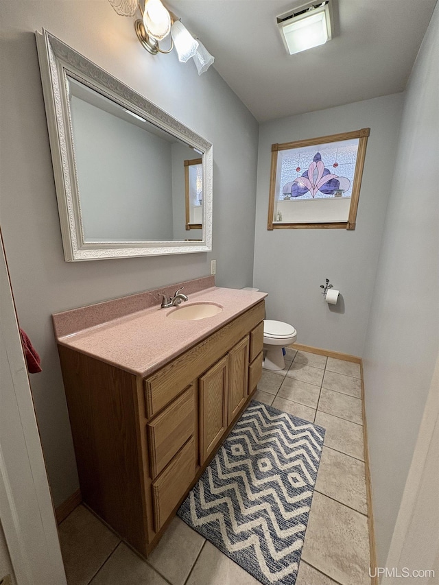 bathroom featuring vanity, tile patterned flooring, and toilet