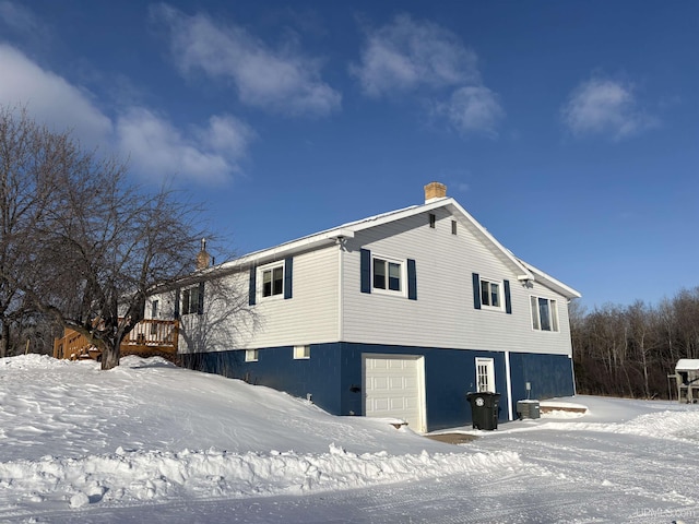 view of snow covered exterior with a garage