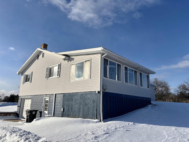 view of snowy exterior featuring a garage