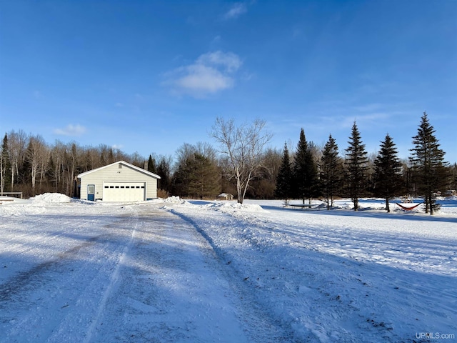 yard layered in snow with a garage and an outdoor structure