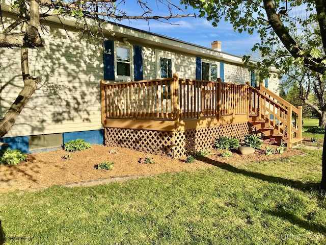 rear view of property featuring a lawn and a deck