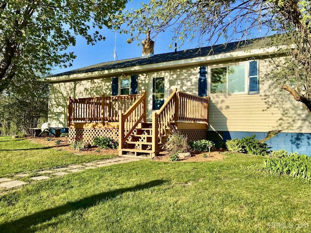 ranch-style home featuring a wooden deck and a front lawn