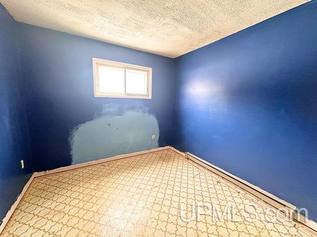 unfurnished room featuring a textured ceiling