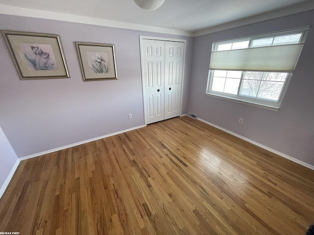 unfurnished bedroom featuring a closet and wood-type flooring