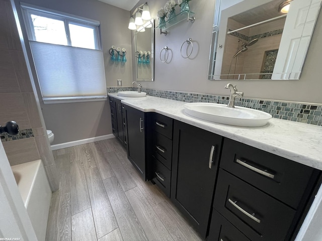 full bathroom featuring backsplash, vanity, hardwood / wood-style floors, and toilet