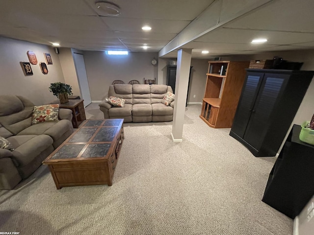 carpeted living room featuring a drop ceiling