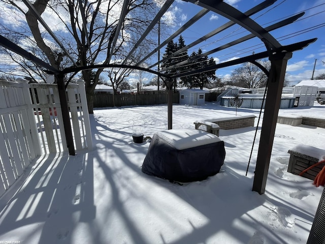 yard layered in snow featuring a storage shed