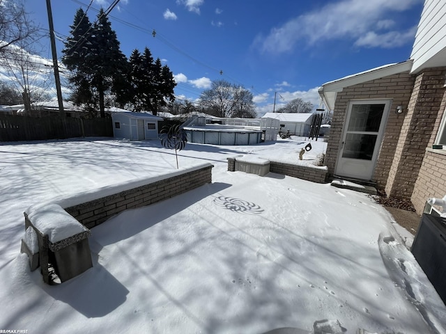 snowy yard featuring a shed