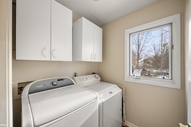 clothes washing area featuring washer and dryer and cabinets