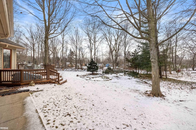 snowy yard featuring a wooden deck