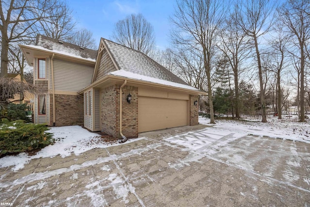 snow covered property with a garage