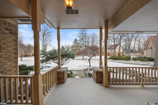 snow covered patio featuring covered porch