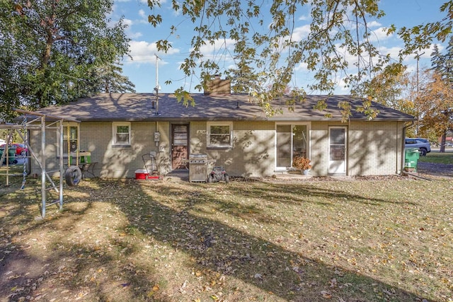 rear view of house featuring a lawn