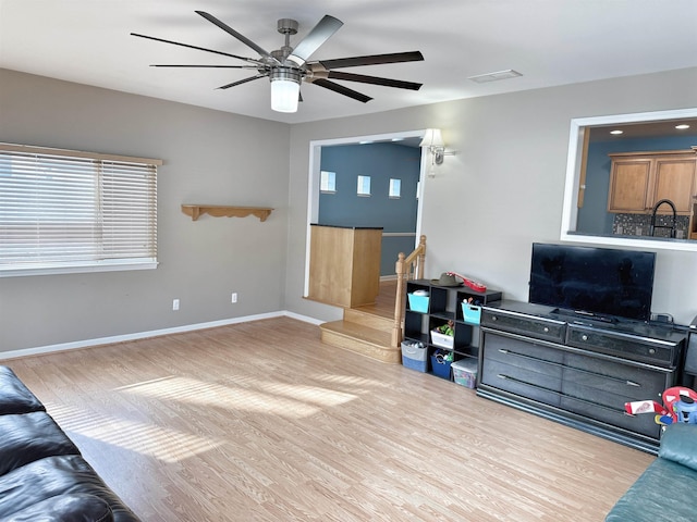 living room featuring ceiling fan and light wood-type flooring