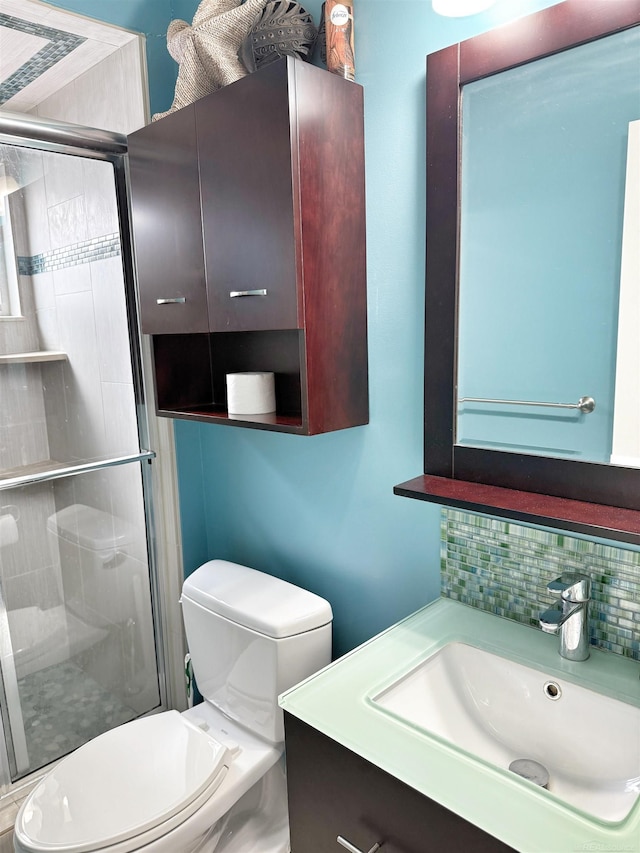 bathroom with vanity, backsplash, toilet, and walk in shower