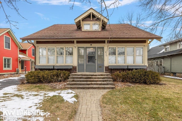 bungalow-style home with a front yard