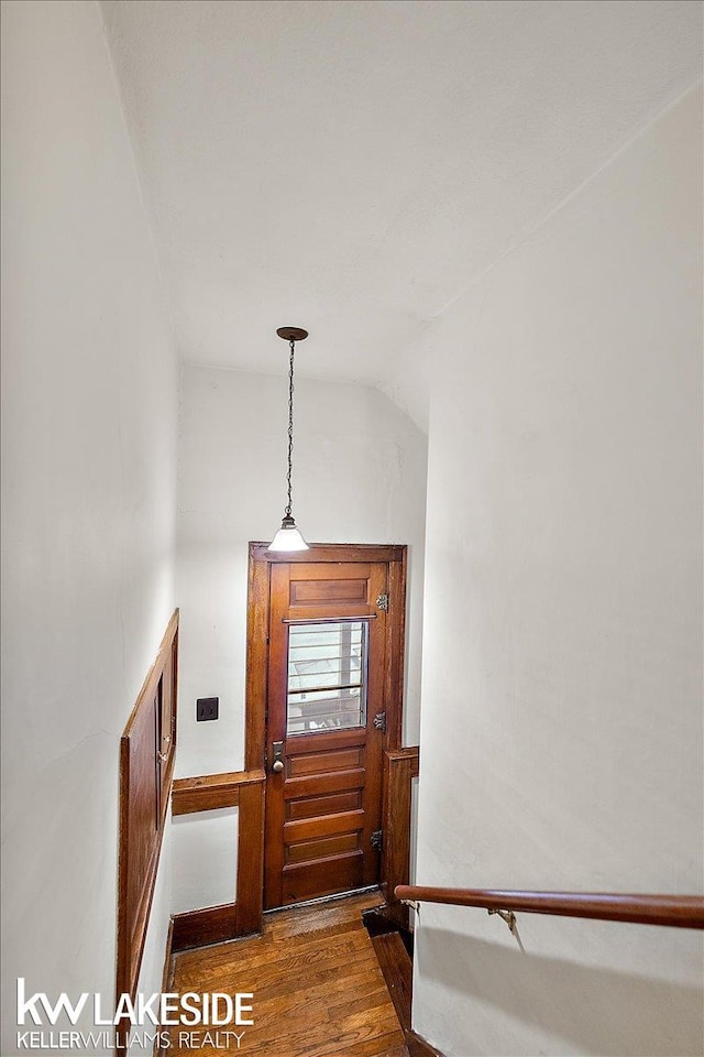 staircase with vaulted ceiling and hardwood / wood-style floors