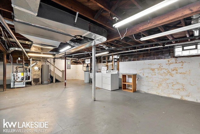 basement with electric panel, washing machine and dryer, and water heater