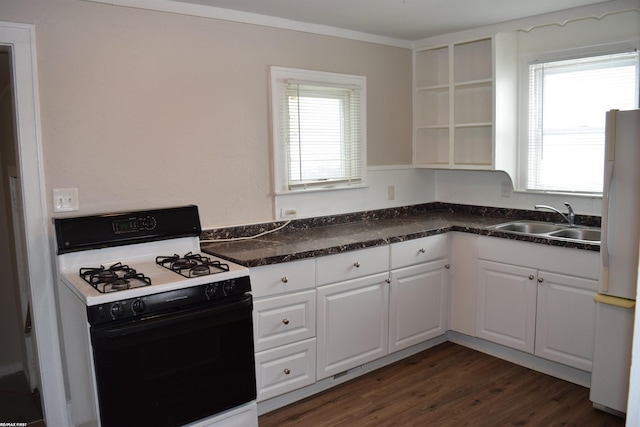 kitchen featuring white fridge, sink, white cabinetry, gas range oven, and dark hardwood / wood-style flooring