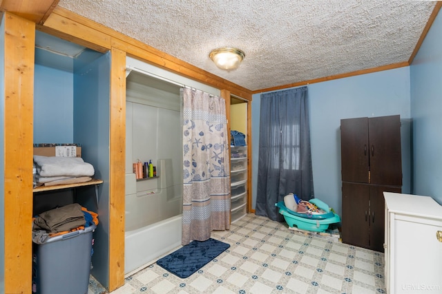 bathroom featuring shower / bath combo with shower curtain, a textured ceiling, and ornamental molding