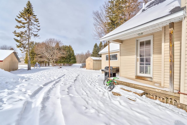 yard layered in snow featuring a storage unit