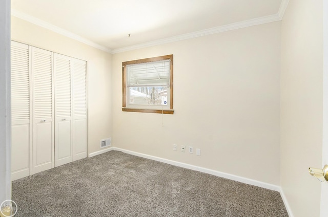 unfurnished bedroom with crown molding, carpet flooring, and a closet