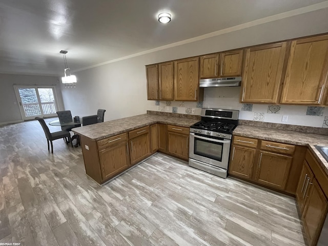 kitchen featuring light hardwood / wood-style flooring, gas stove, pendant lighting, kitchen peninsula, and ornamental molding