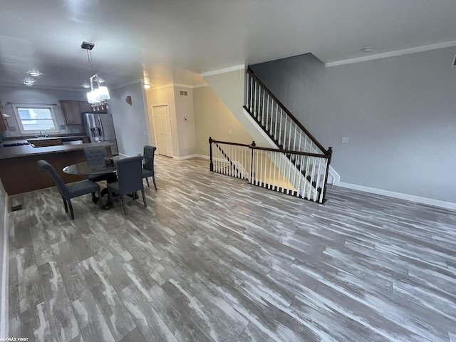 living room featuring hardwood / wood-style flooring, crown molding, and a notable chandelier