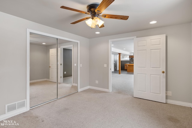 unfurnished bedroom with light carpet, ceiling fan, and a closet