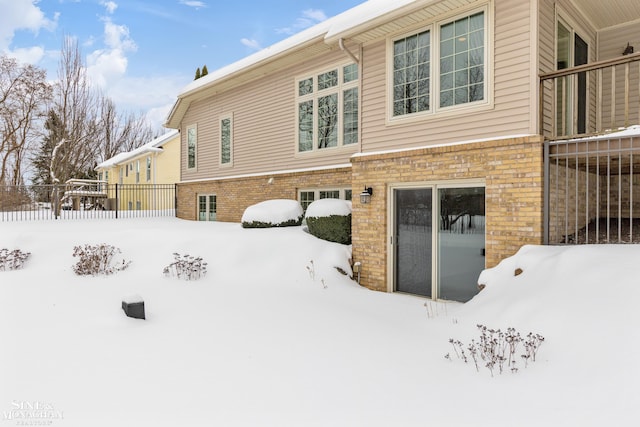 view of snow covered back of property