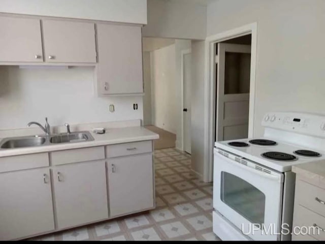 kitchen featuring white cabinets, sink, and white electric range