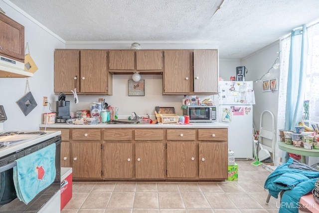 kitchen featuring white appliances, a textured ceiling, light tile patterned flooring, crown molding, and sink