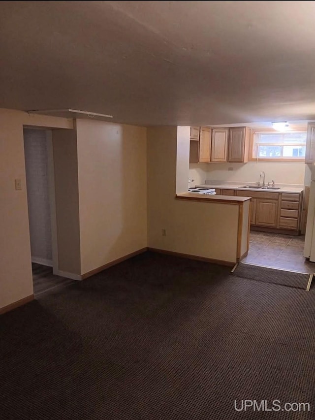 kitchen with light carpet, electric range, light brown cabinets, sink, and kitchen peninsula