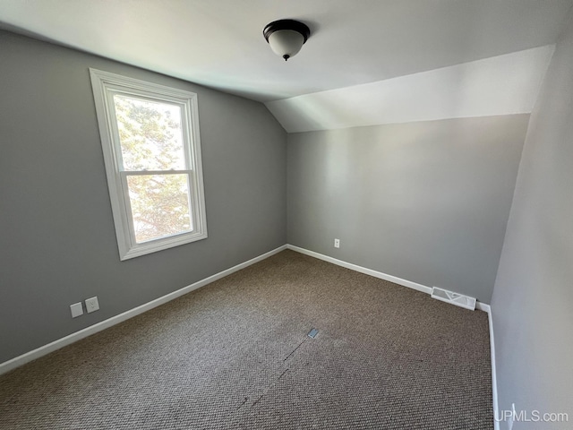 bonus room with lofted ceiling and carpet flooring