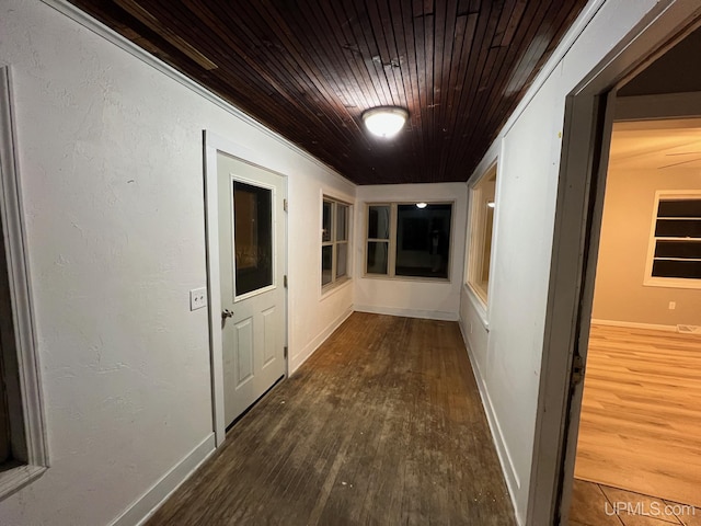 corridor featuring dark wood-type flooring and wooden ceiling