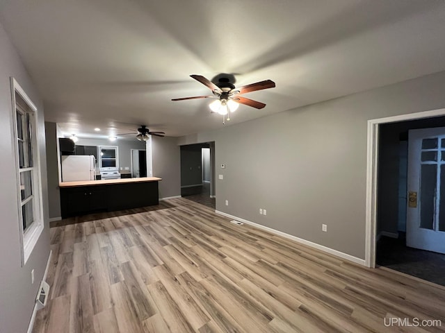 unfurnished living room featuring ceiling fan and wood-type flooring