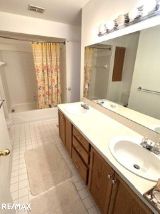 full bathroom with tile patterned floors, shower / bath combo, vanity, and toilet