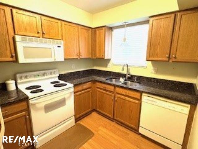 kitchen with sink, white appliances, and light wood-type flooring