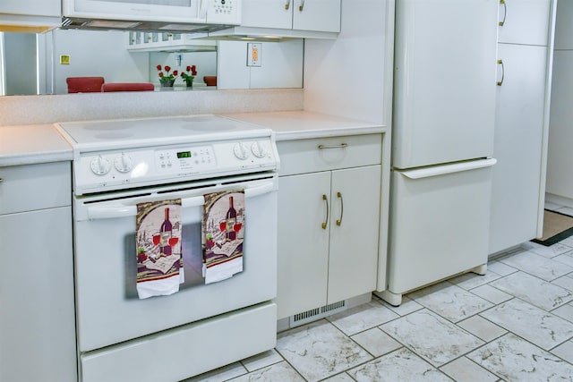 kitchen featuring white appliances and white cabinets