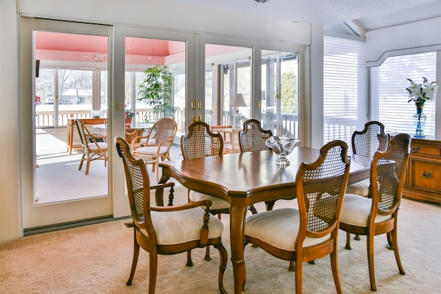 dining area with light carpet and a wealth of natural light