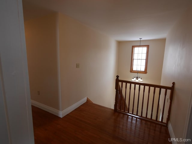 hall featuring dark hardwood / wood-style flooring and a chandelier