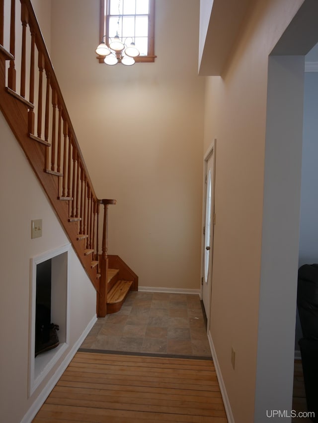 foyer with an inviting chandelier, light hardwood / wood-style flooring, and a high ceiling