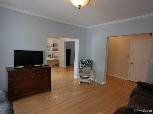 living room with light hardwood / wood-style floors and crown molding