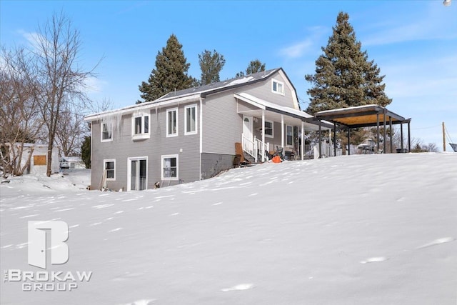 view of snowy exterior featuring a porch