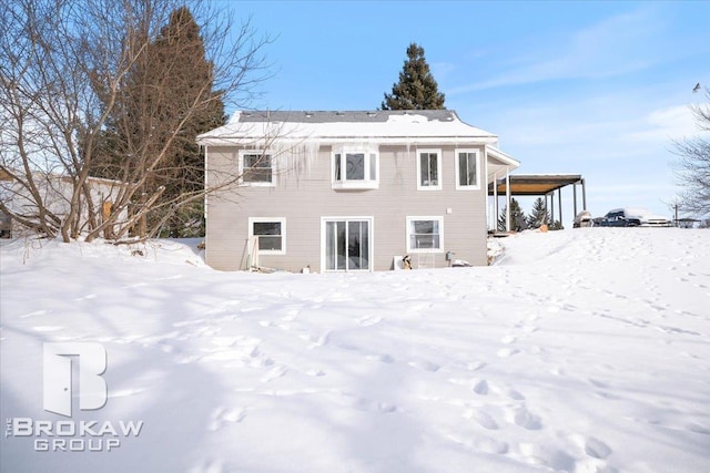 view of snow covered back of property